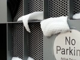 Snowdrifts peeling away from metal gate